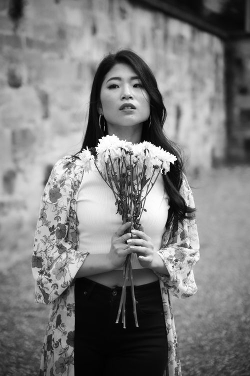 Free A woman in floral attire holding flowers, captured in a vintage style. Stock Photo