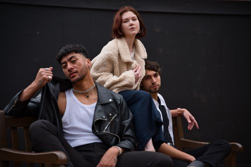 Free Three fashionable adults sitting confidently in an indoor setting, exuding style and attitude. Stock Photo