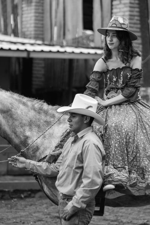 Free Traditional cowboy and cowgirl in Mexico City attire, captured on horseback. Stock Photo