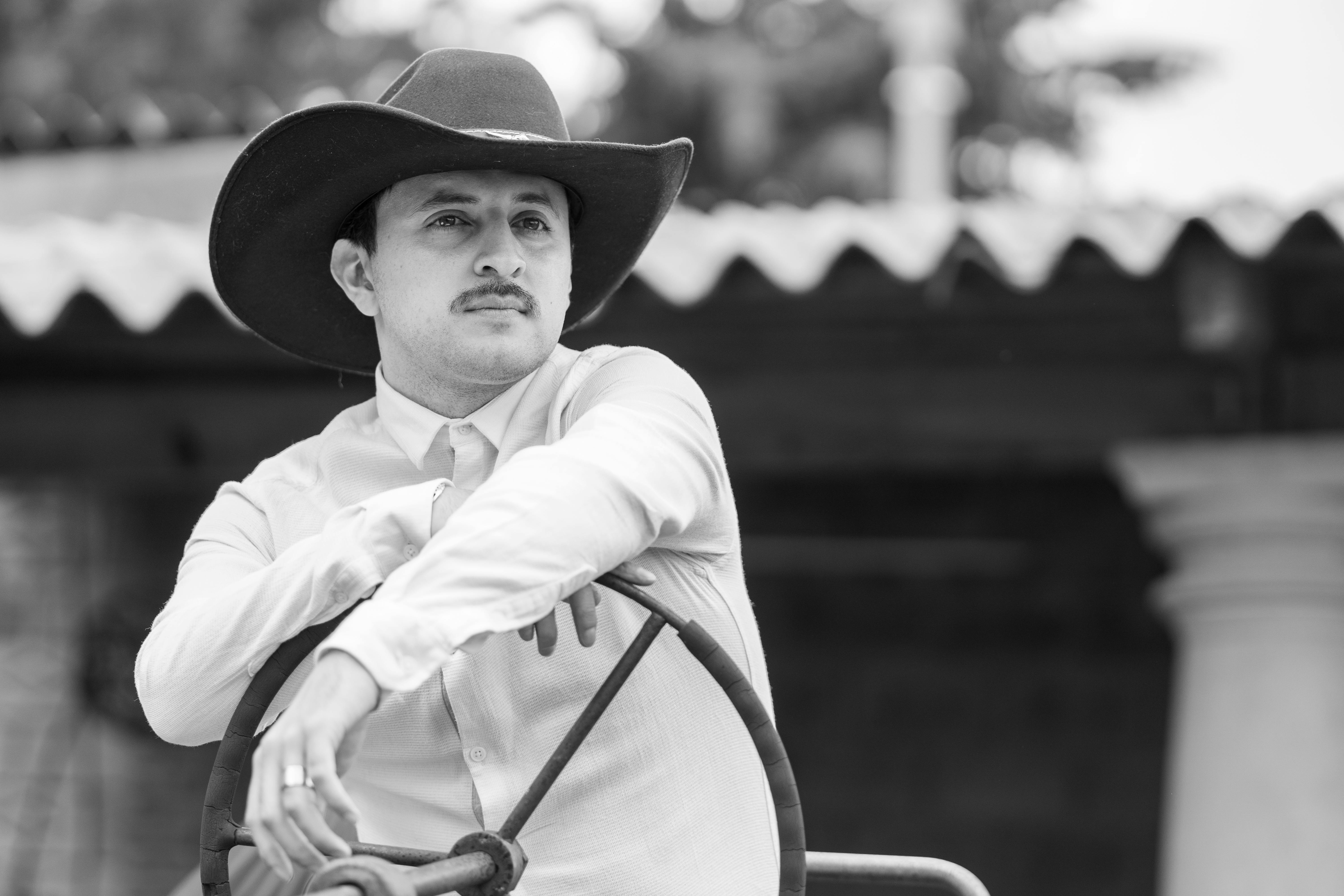 a man in a cowboy hat sitting on a wheel