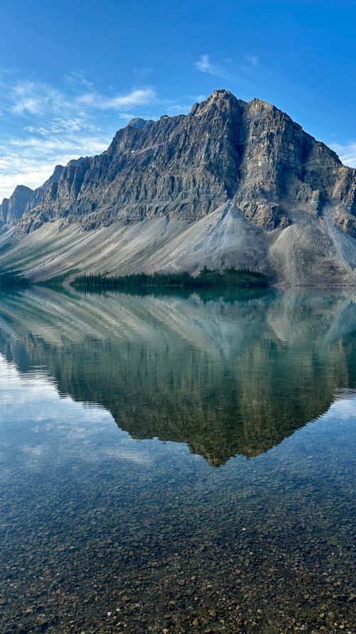 Free Breathtaking mountain landscape with pristine lake reflection under a clear blue sky. Stock Photo