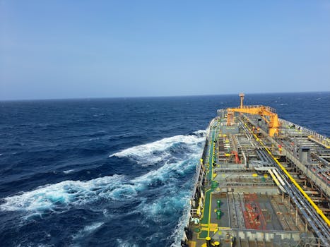 Cargo ship navigating through the ocean under clear skies, showcasing maritime transportation.