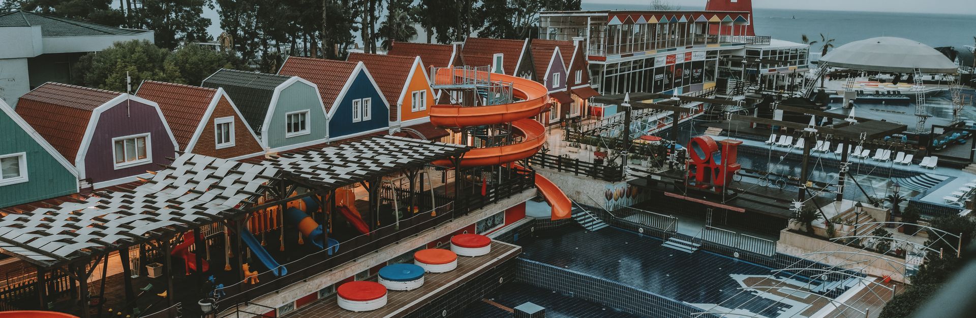 A colorful coastal resort in Antalya, Turkey with vibrant buildings and water slides.