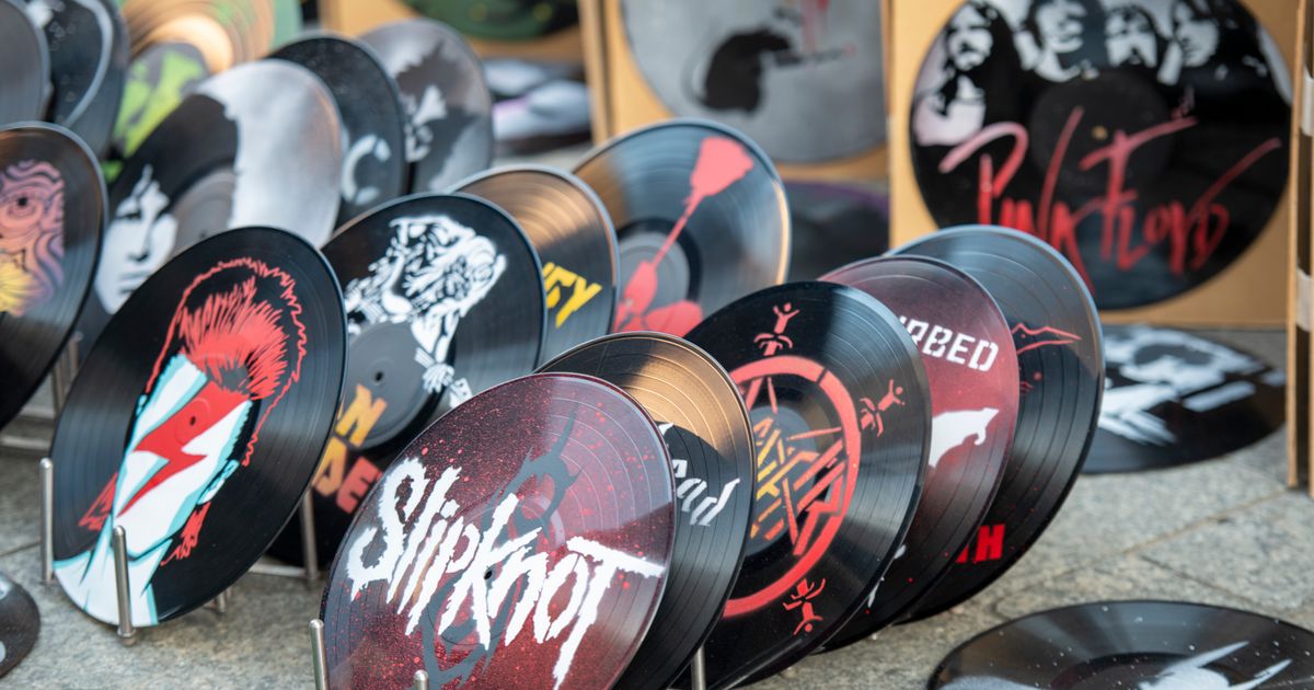 Collection of artistic vinyl records featuring iconic band designs on display at market.