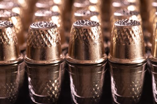 Free Detailed shot of brass thimbles arranged in neat rows reflecting light. Stock Photo