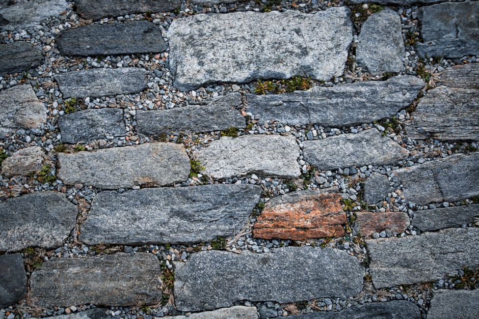 Close-up of weathered stone pavement showcasing textured natural rock formations and earthy tones.