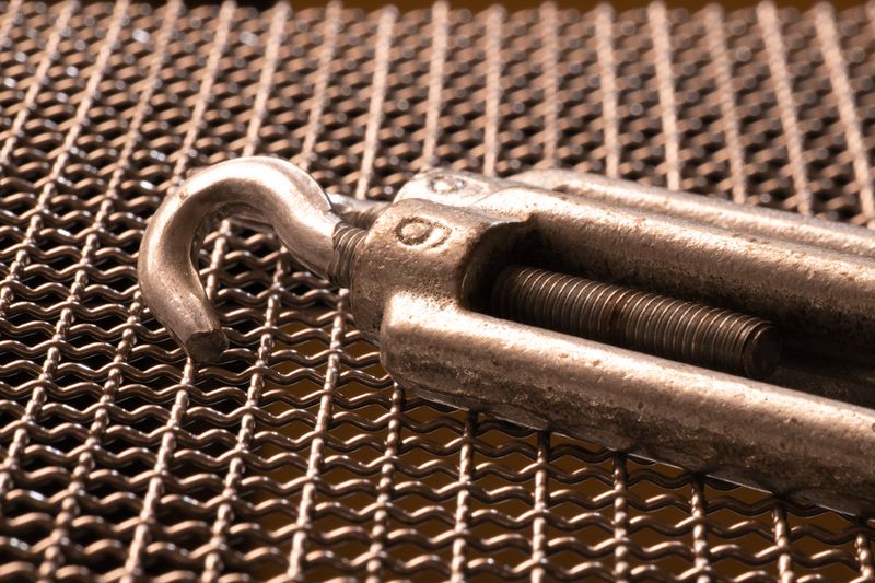 Detailed shot of a metal hook on a grid mesh