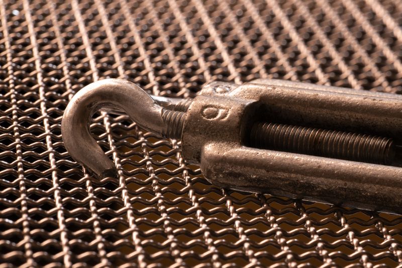 Metal hook on intricate woven mesh