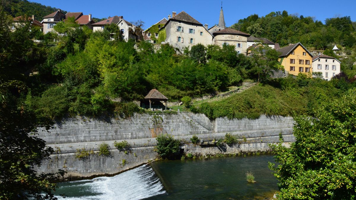 A honey-stone Jura village above the green river