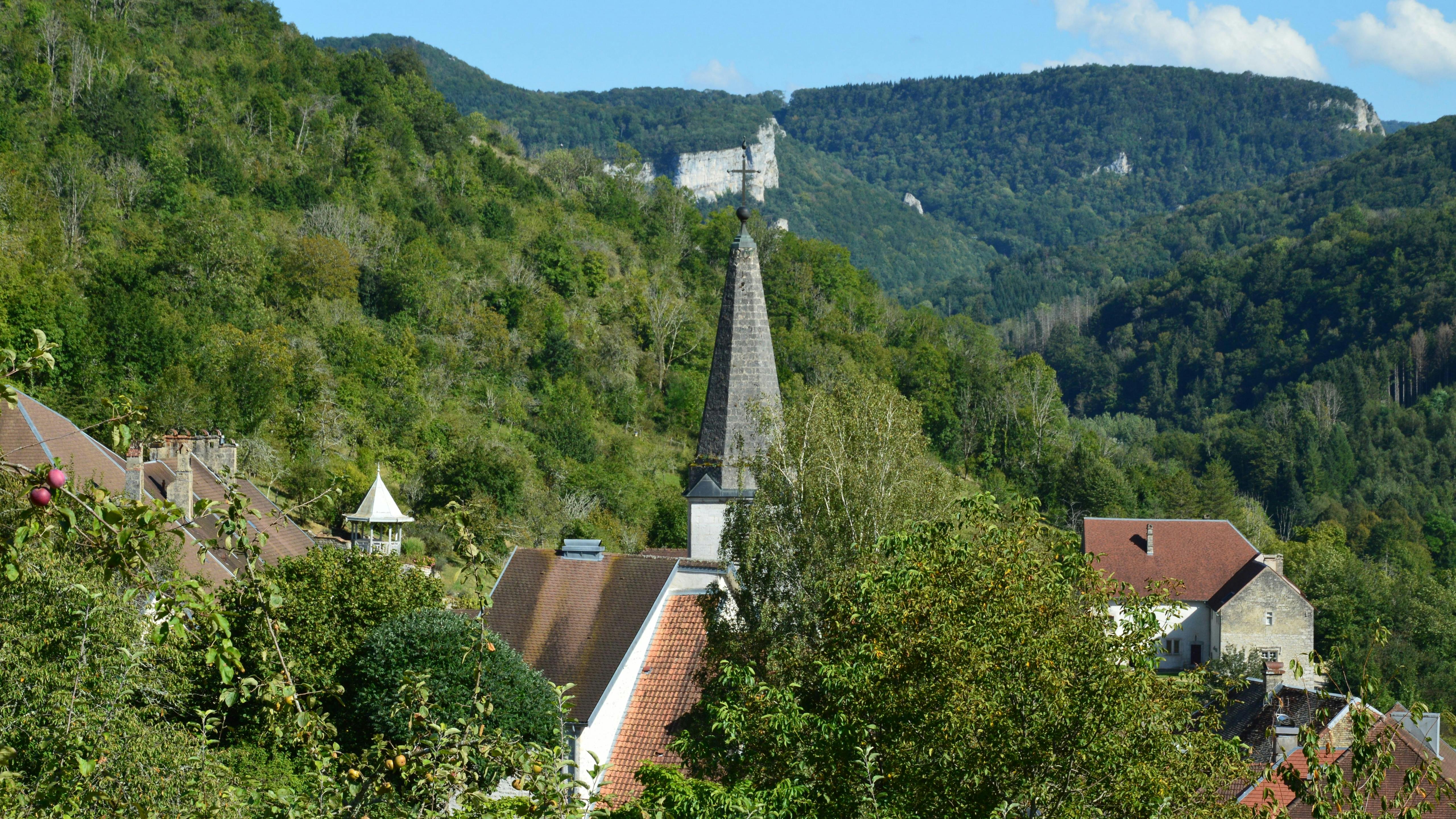 Discover the picturesque village of Lods in Bourgogne-Franche-Comté, France, nestled among lush green hills.