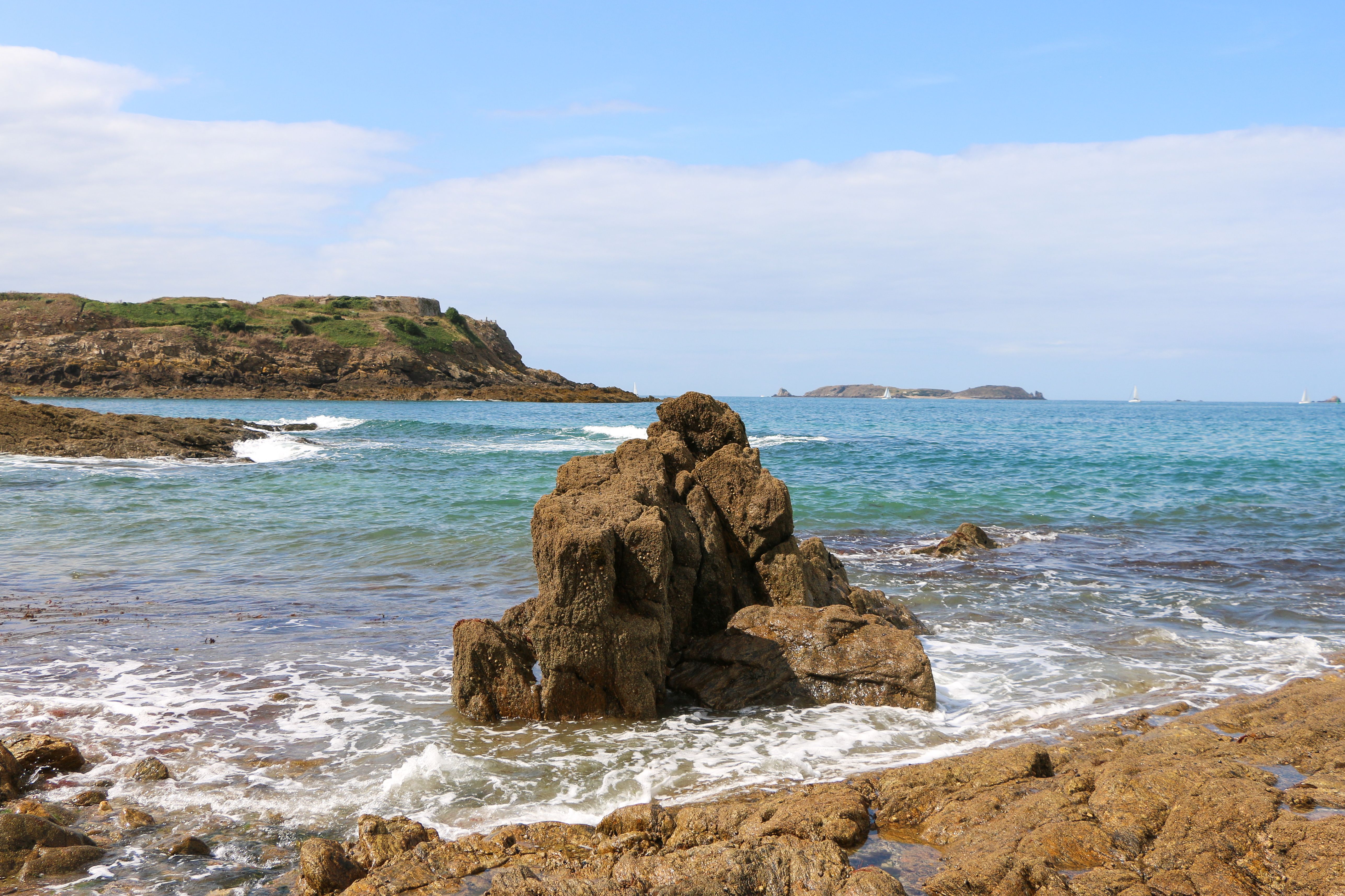 Explore the rugged beauty of a rocky seashore with cliffs and waves in a summer landscape.