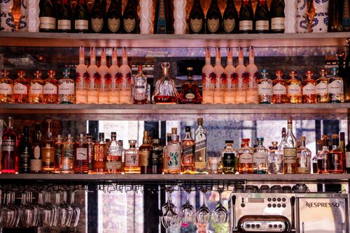 Free A well-stocked bar display featuring various bottles of liquor and glassware, perfect for nightlife scenes. Stock Photo
