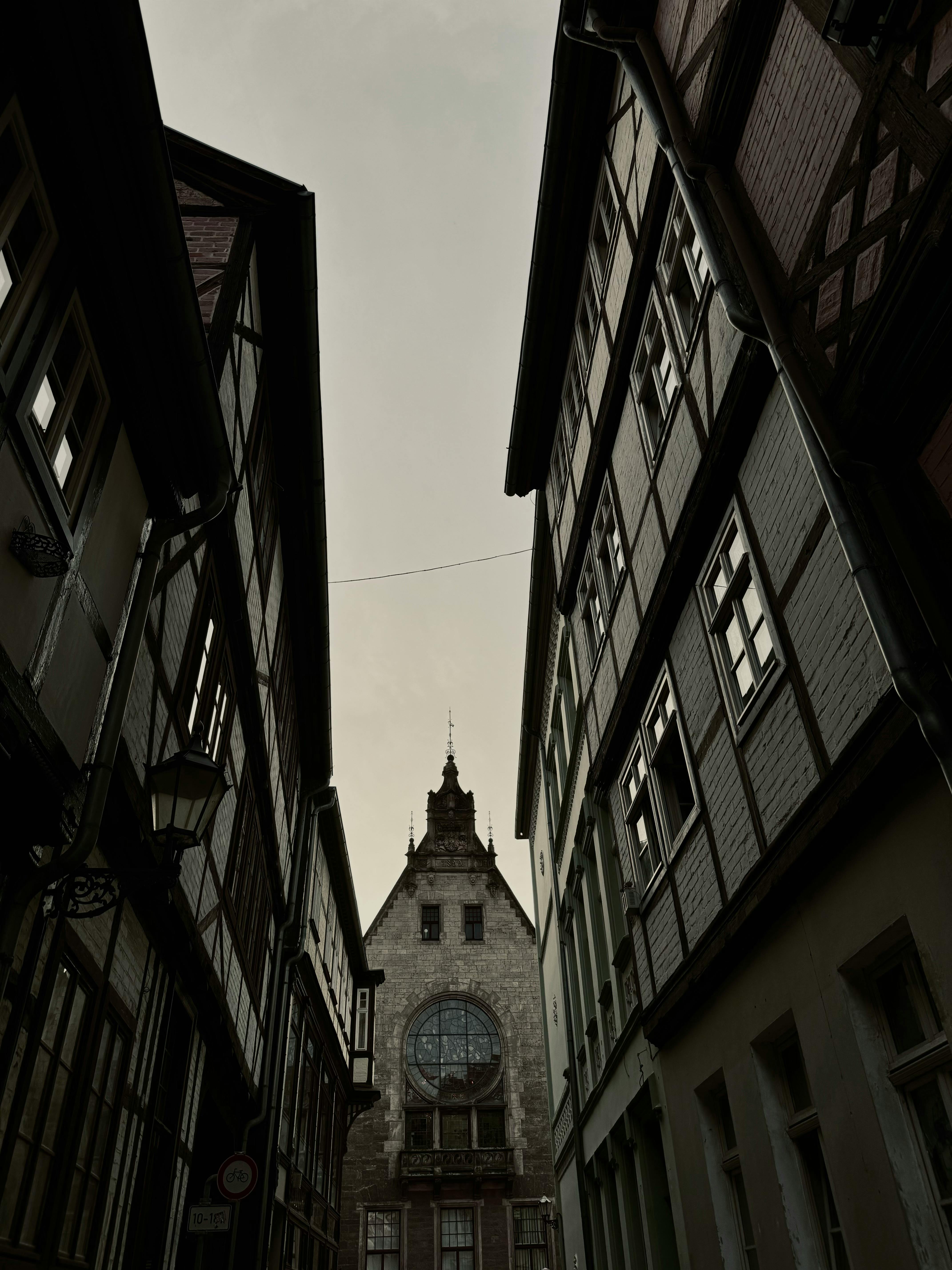 a narrow street with buildings and a church