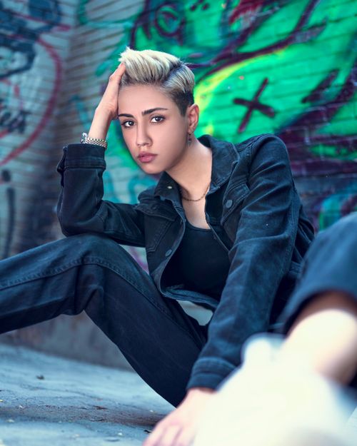 Free Elegant woman in fashion-forward pose against graffiti wall in Tehran, Iran. Stock Photo