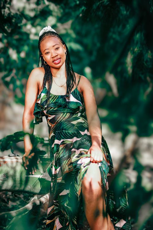 Free A stylish woman in a tropical dress enjoying the outdoors with a vibrant backdrop. Stock Photo