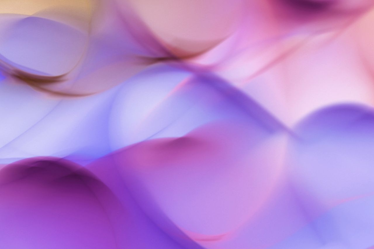 a smooth abstract design with vibrant purple and pink waves creating a