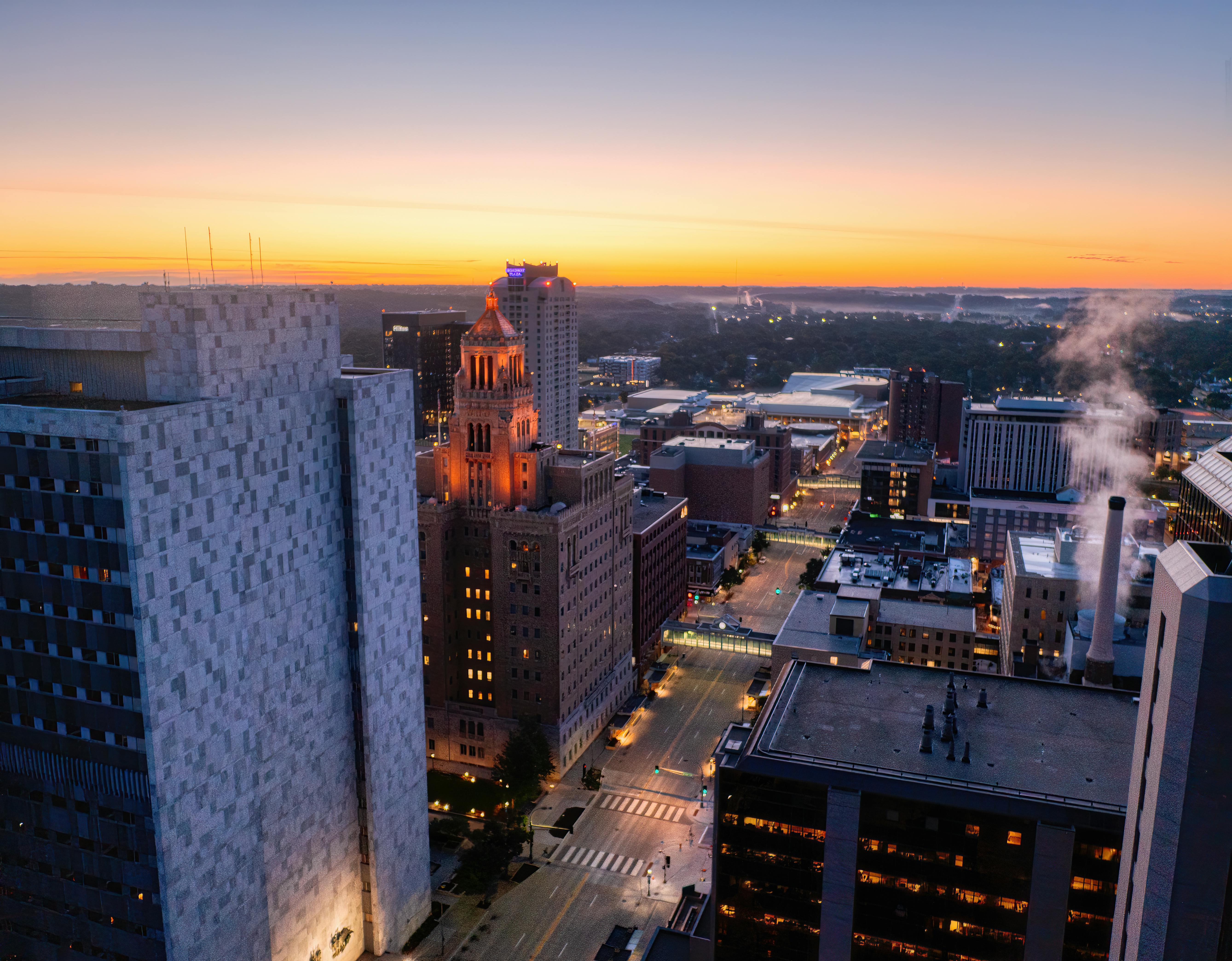 A breathtaking view of Rochester, MN skyline at sunset with modern architecture and vibrant city lights.