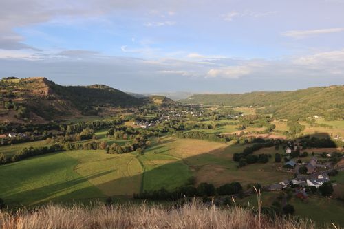 Free A picturesque view of green fields and rolling hills under a clear sky. Stock Photo