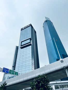 View of contemporary skyscrapers under a cloudy sky in an urban cityscape.