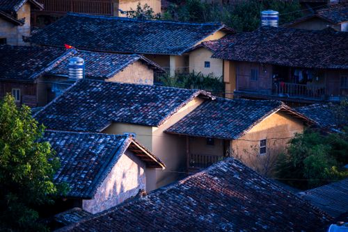 Free Charming view of traditional village rooftops under the soft light of twilight. Stock Photo
