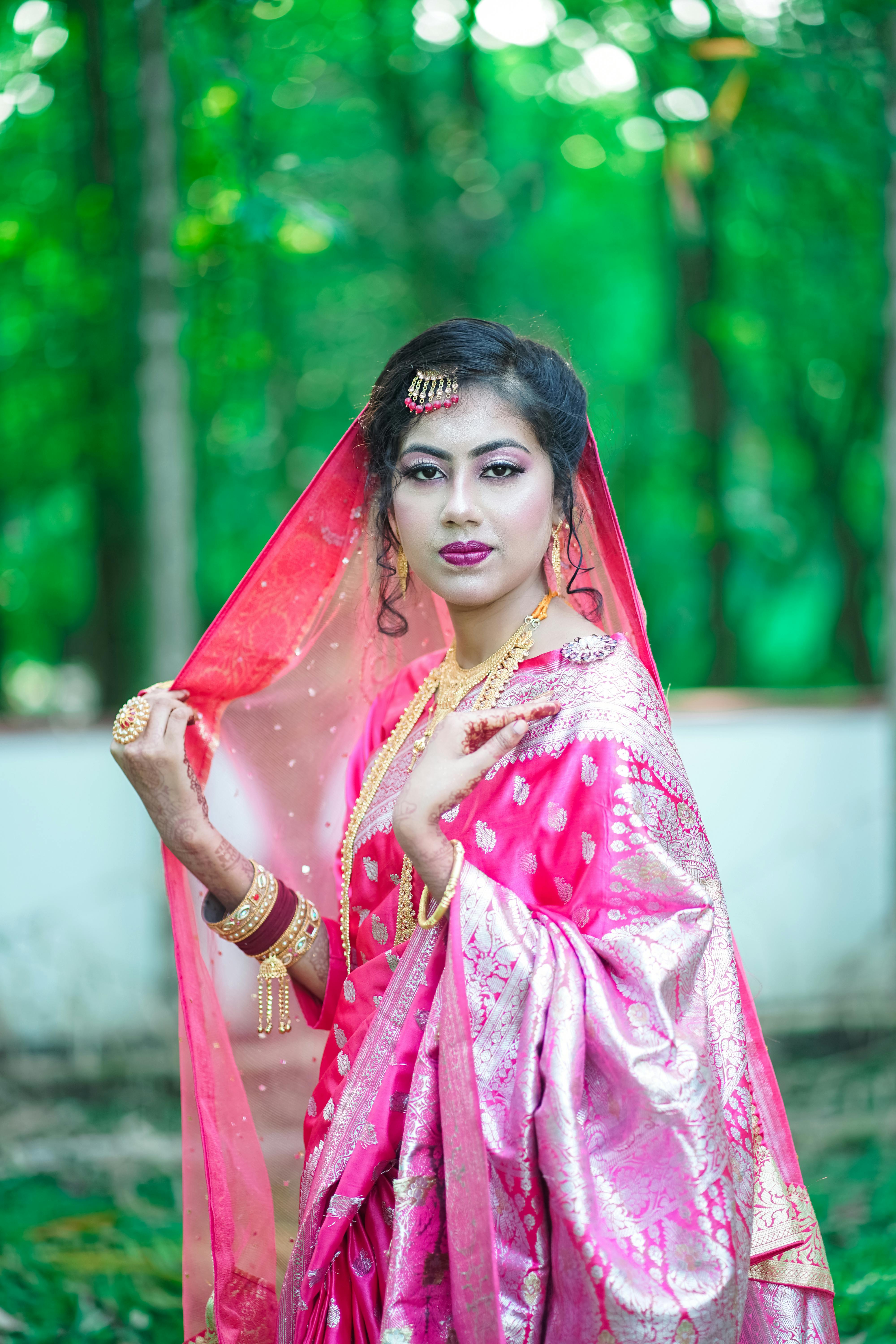 a beautiful woman in pink sari posing for the camera