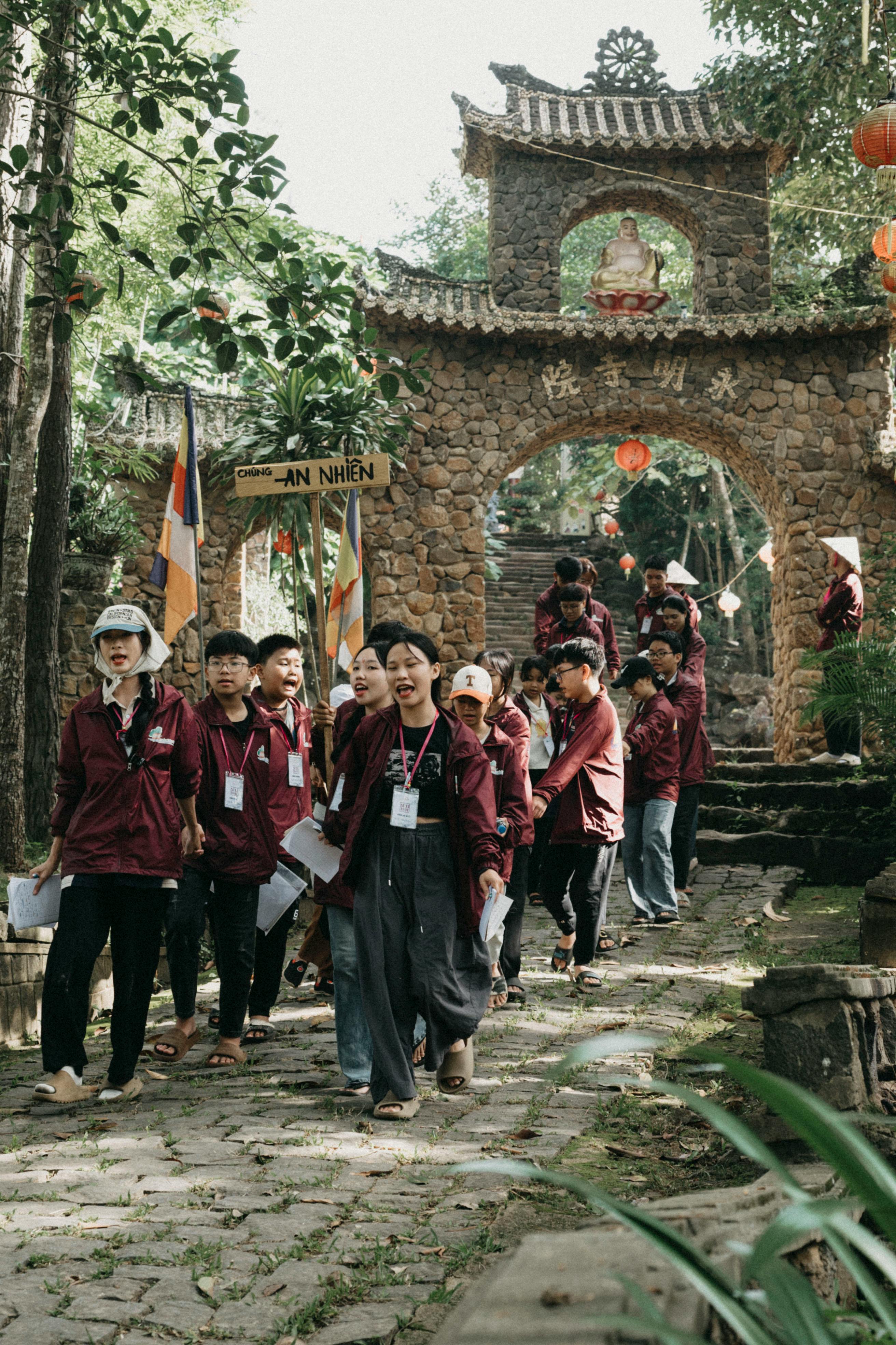 A group of adults visits a historic stone gate, exploring the cultural heritage site.