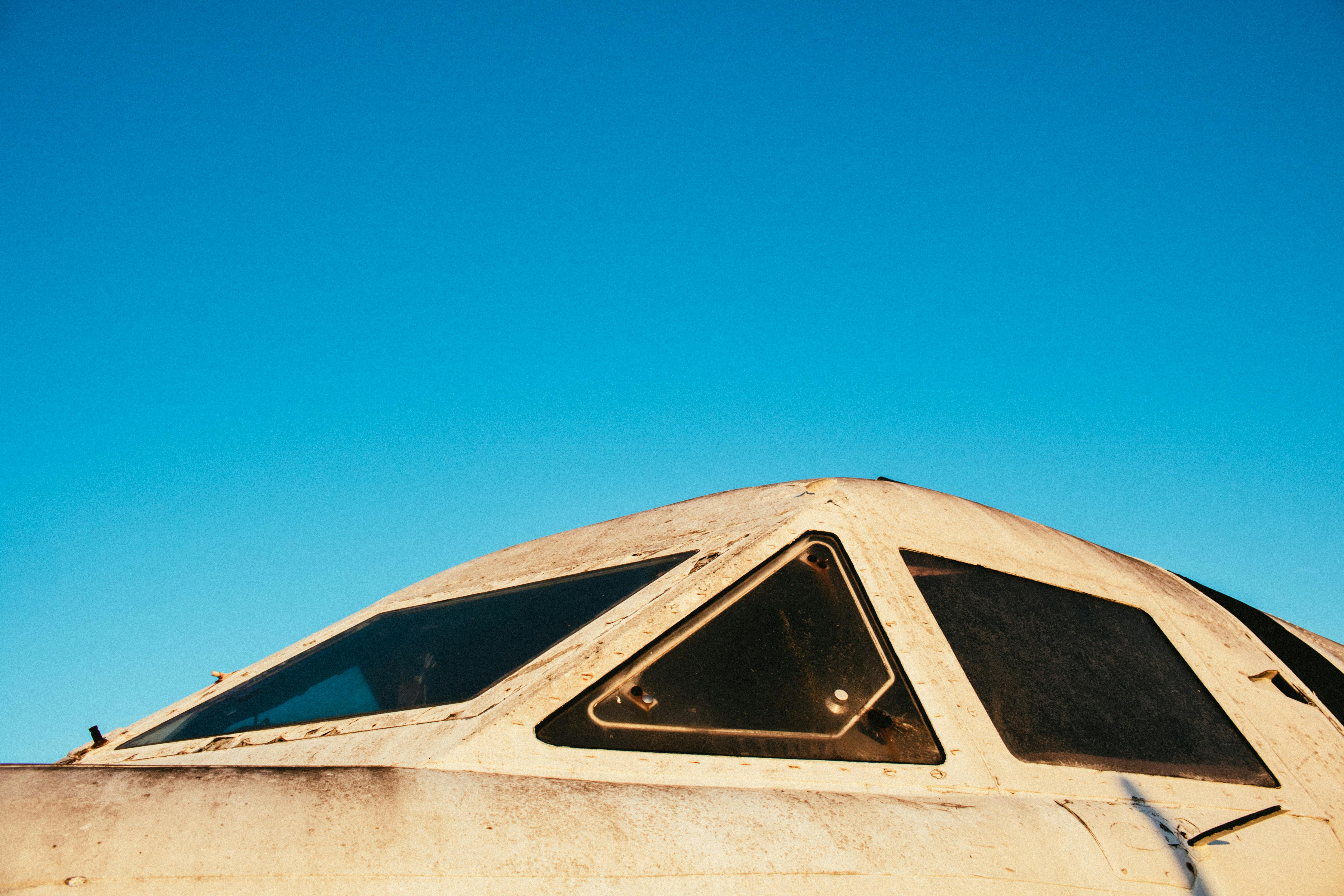 特写镜头捕捉了老式飞机驾驶舱与晴朗蓝天，展现航空历史