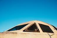 特写镜头捕捉了老式飞机驾驶舱与晴朗蓝天，展现航空历史