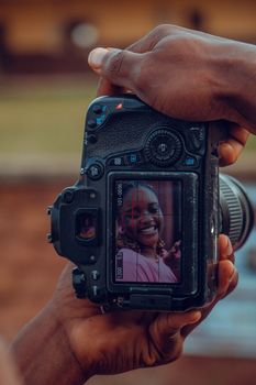 Close-up of a digital camera screen showing a woman's portrait outdoors.