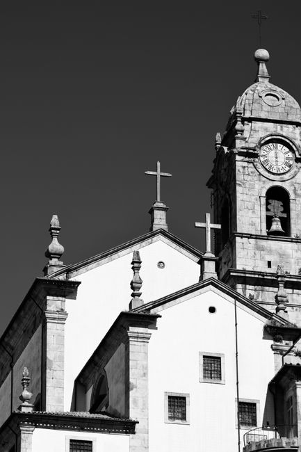 Black and white photo of a historic church tower in Lisbon, Portugal, showcasing Gothic architecture.