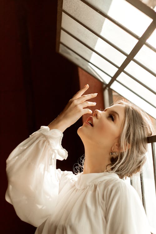 Woman Wearing White Long-Sleeved Blouse While Looking Upward