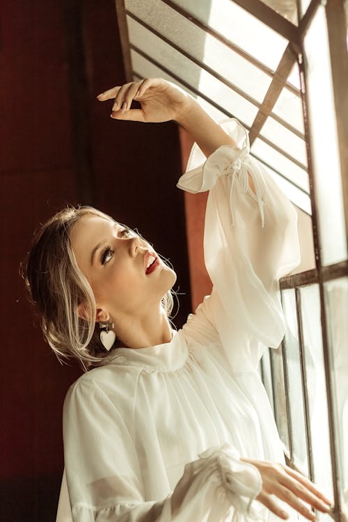 Woman Wearing White Blouse Standing Beside Window