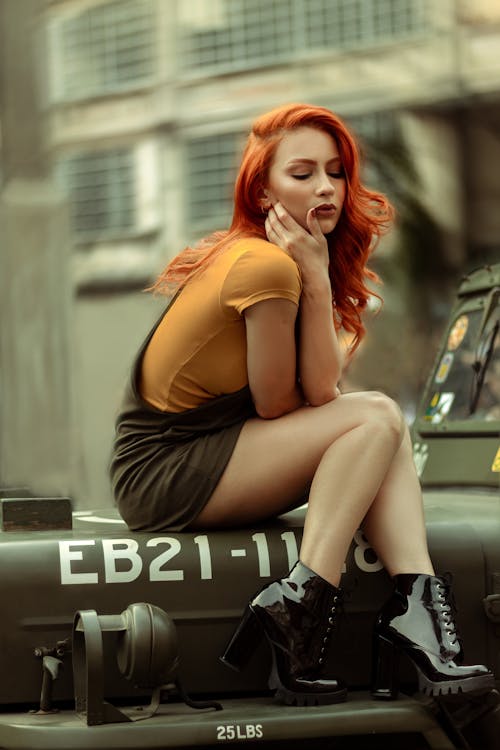 бесплатная Женщина, сидящая на капоте автомобиля Стоковое фото