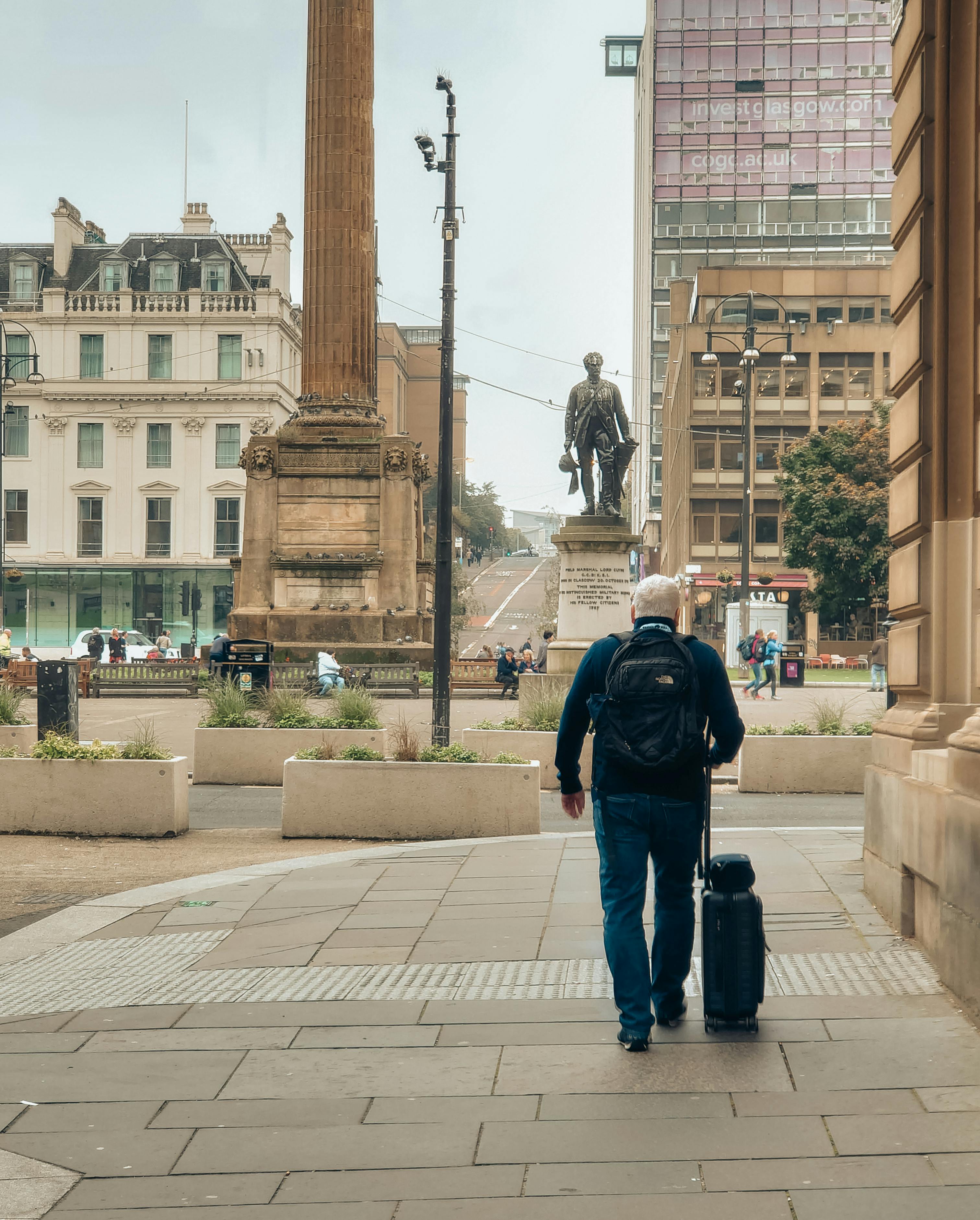 a man walking down a street with a suitcase