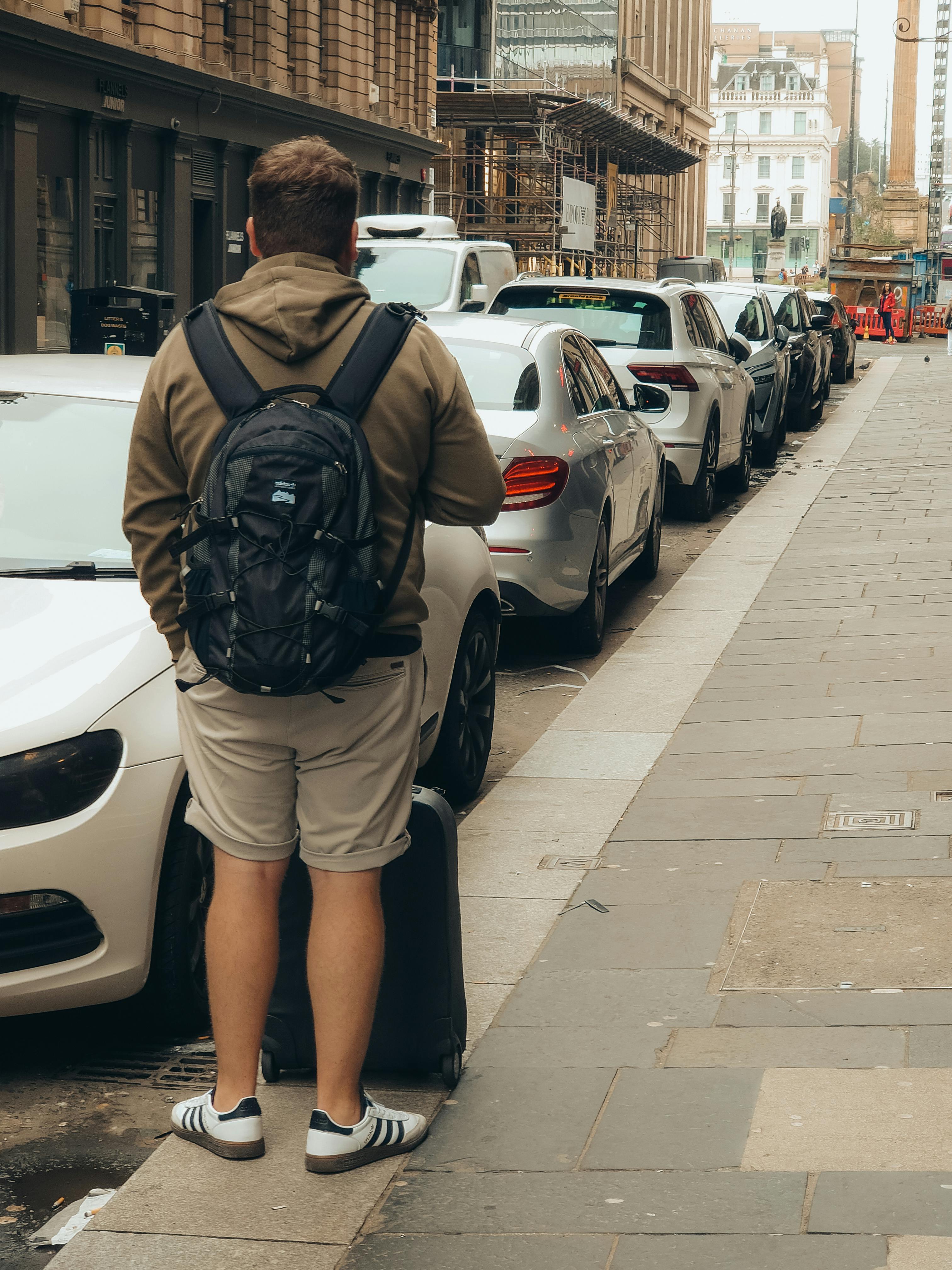 a man with a backpack standing on a street