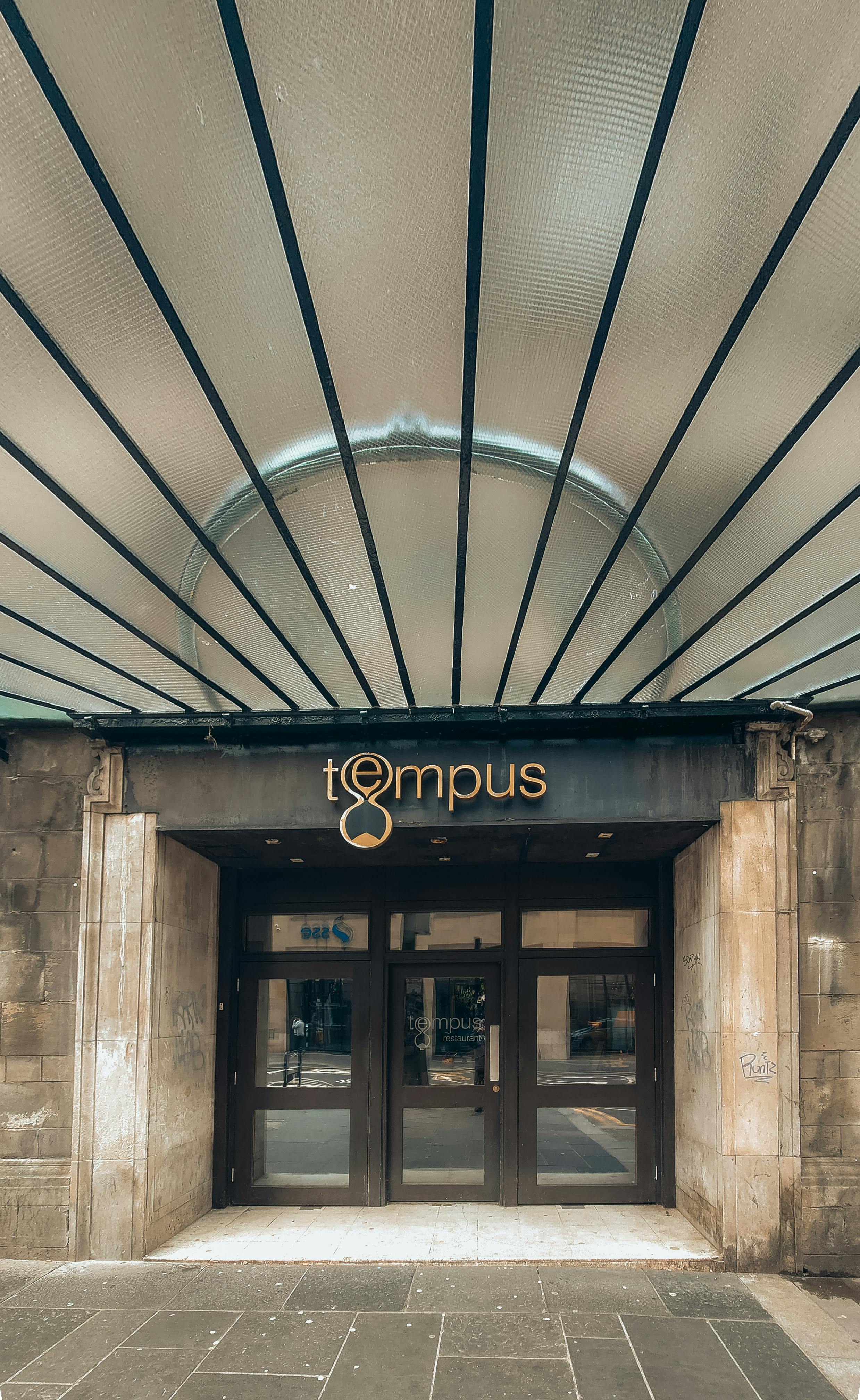 the entrance to a hotel with a sign that says tupus