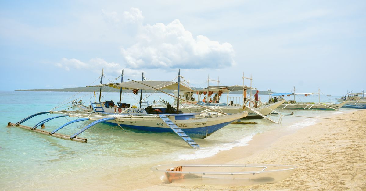 Traditional boats on a sunny Kalibo beach in the Philippines, perfect for tropical getaways.