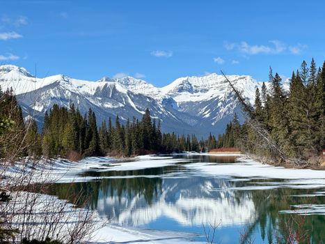 A breathtaking view of snow-covered mountains and a reflective lake in Banff National Park.