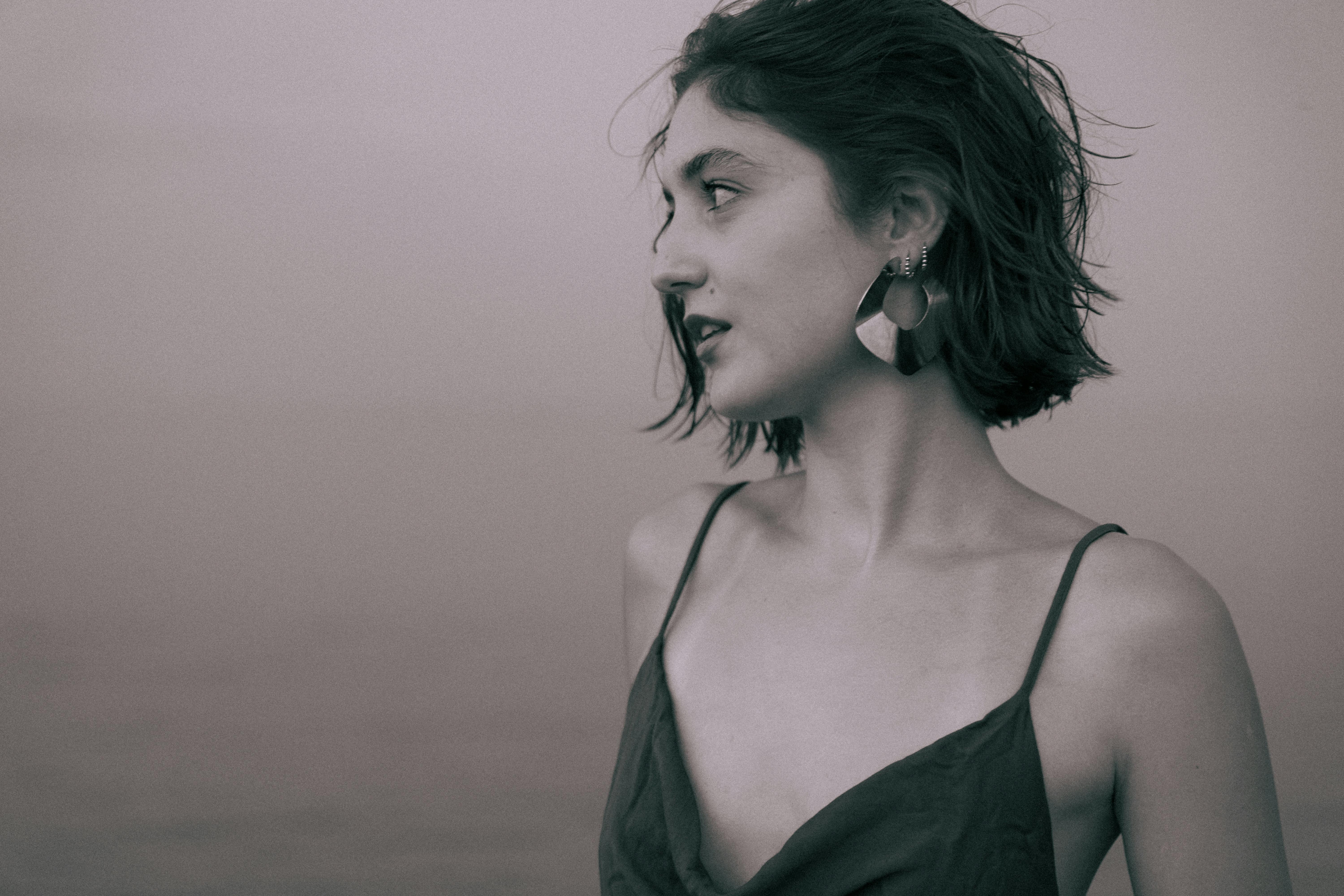 a woman in a black dress standing by the water