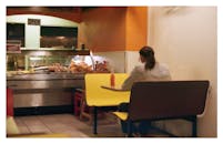 一个人独自坐在一家色彩鲜艳、食物陈列舒适的餐厅里