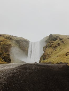 斯科加福斯瀑布被薄雾笼罩，周围环绕着崎岖的风景，在冰岛体验它令人惊叹的魅力