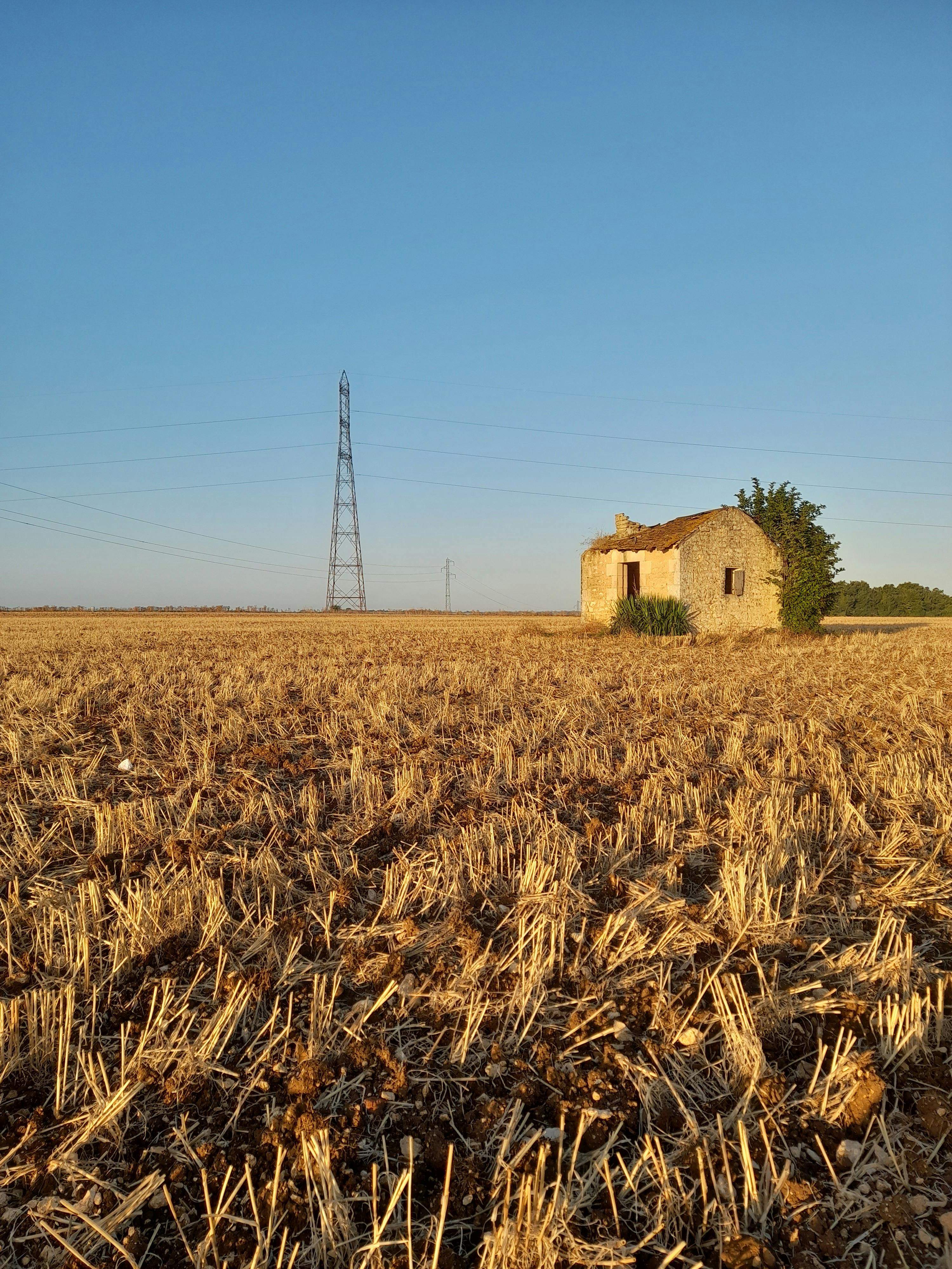 an old house in a field with a power line