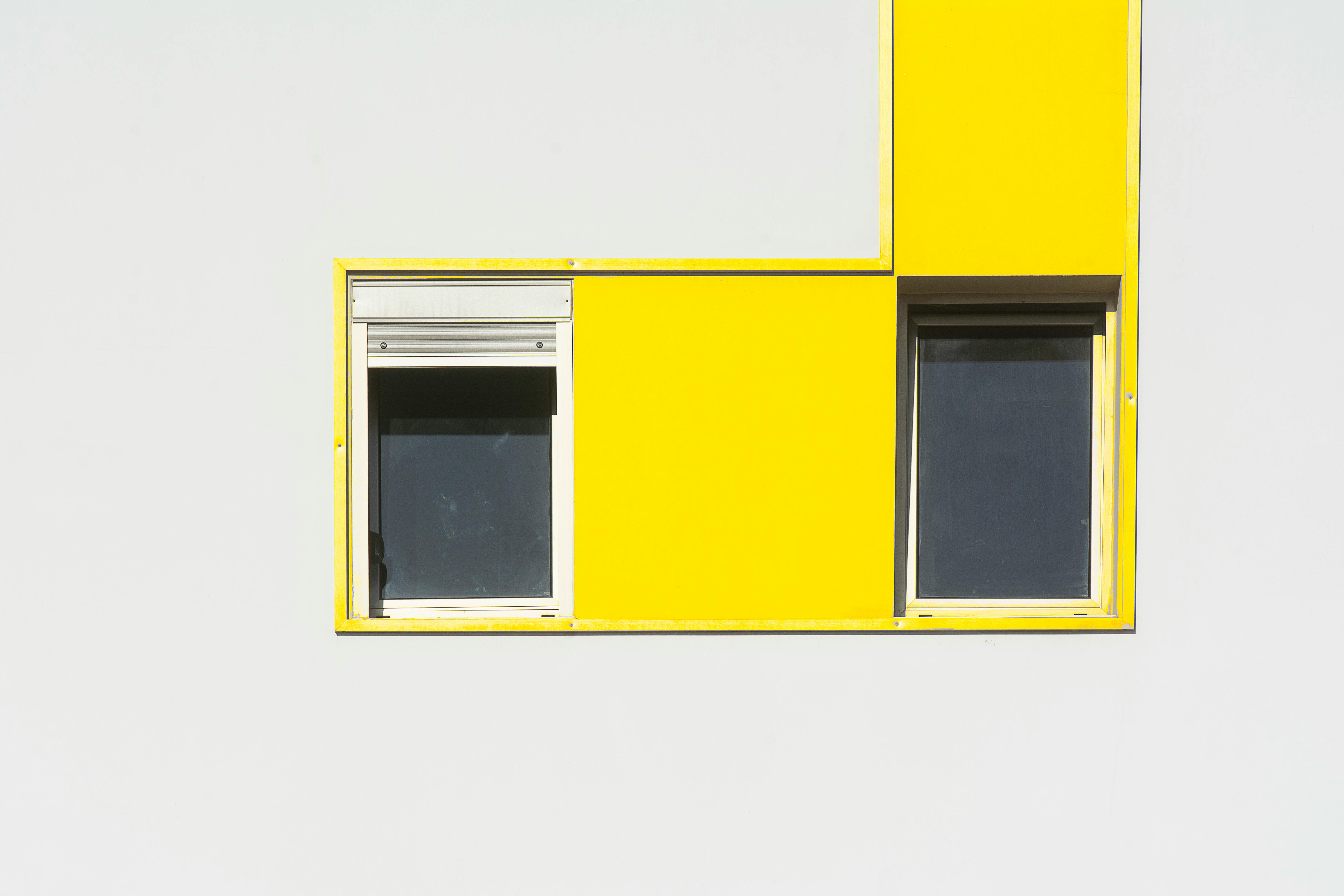 a yellow and white building with two windows