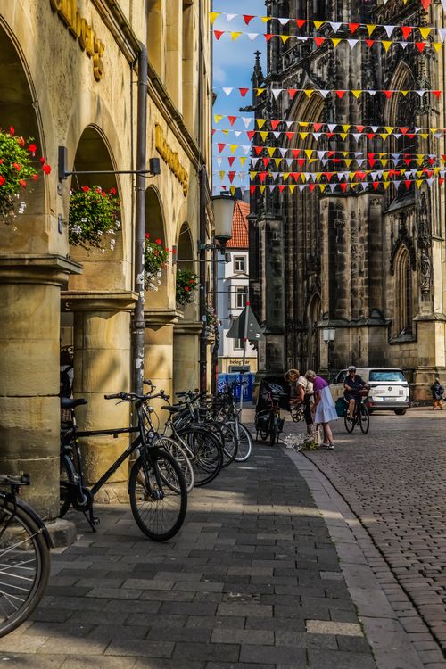 Free Gothic architecture street scene with bikes and people in a European city. Stock Photo