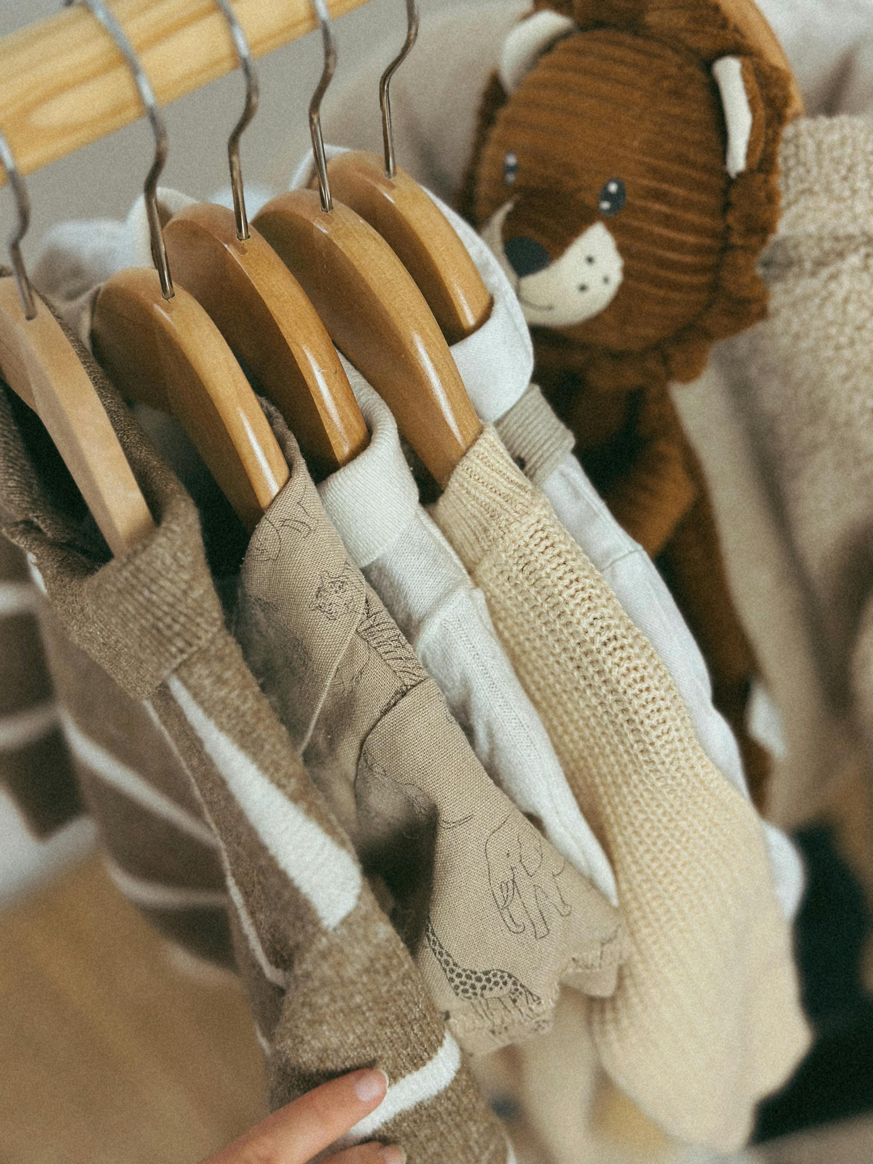 Warm, neutral-toned baby clothes with a cute lion toy.