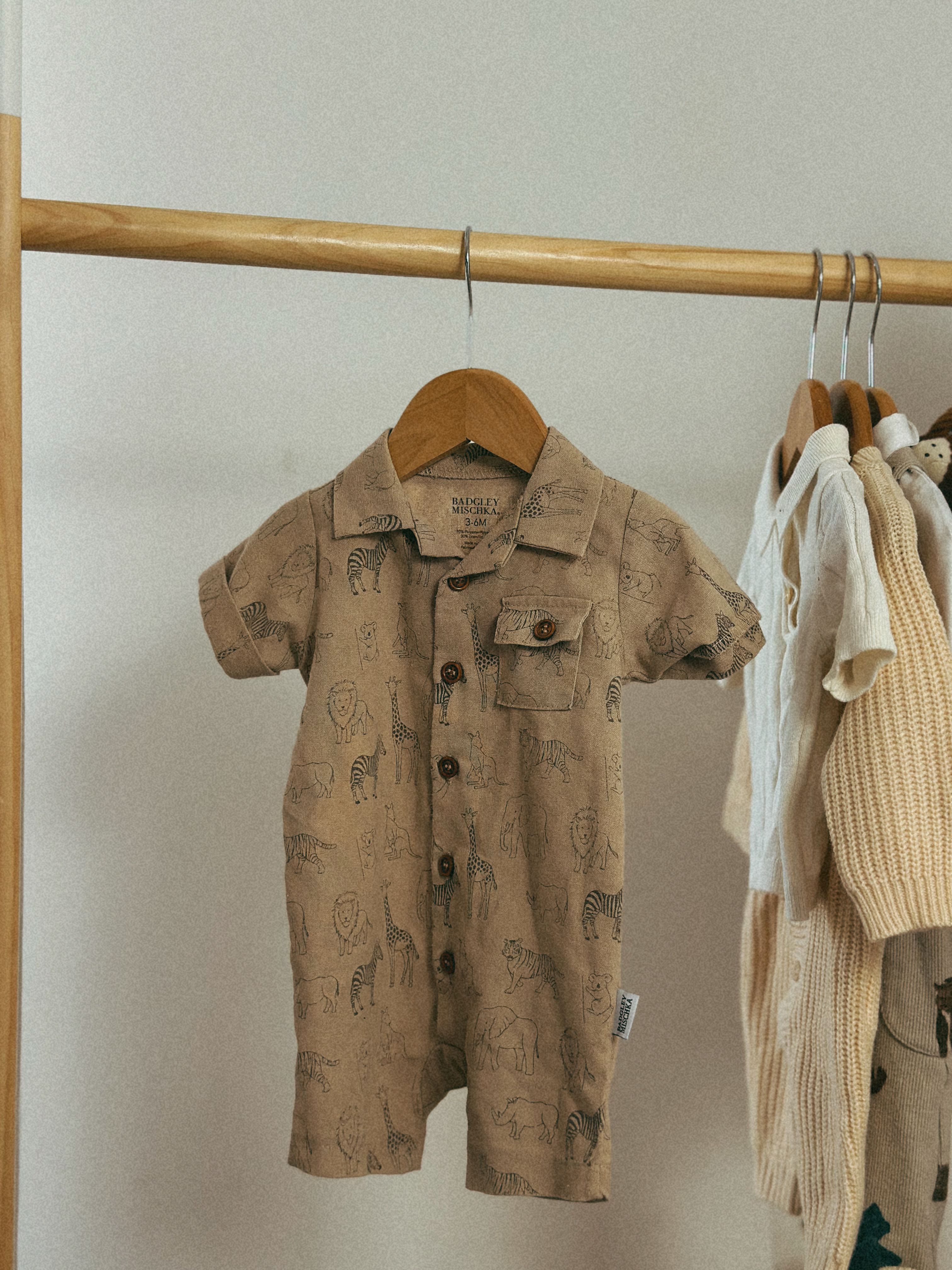 Adorable baby romper with animal prints in a cozy indoor setting.