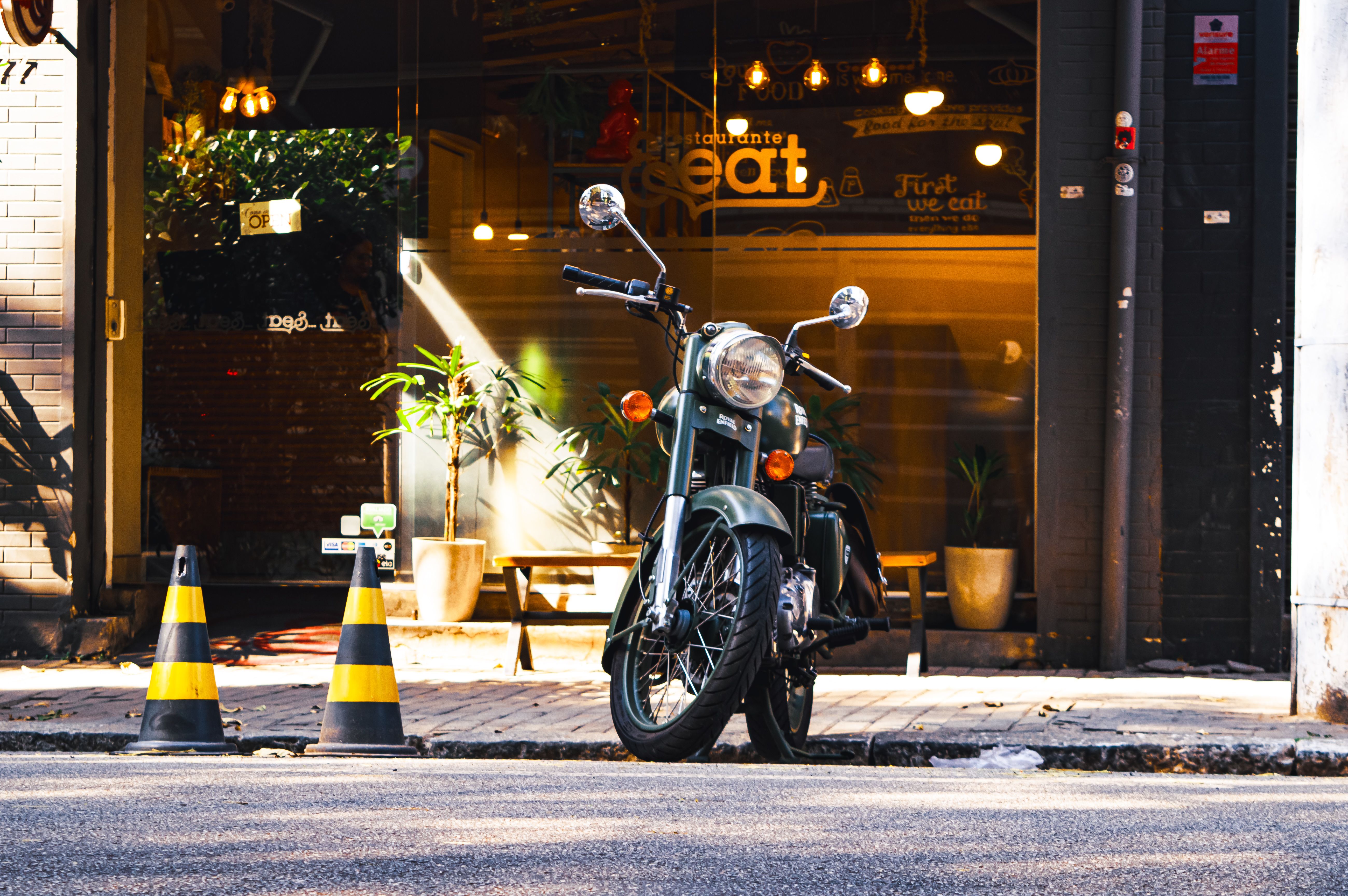 Common Mistakes to Avoid — A vintage motorbike stands beside a cozy cafe on a sunny urban street.