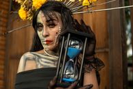 Artistic portrayal of Día de los Muertos Catrina holding an hourglass, symbolizing Mexican cultural traditions.