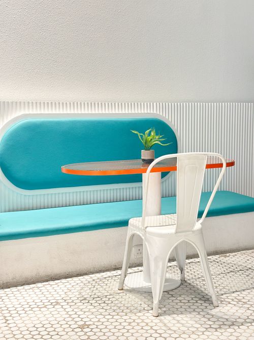 Free A bright modern seating area with a turquoise bench and white chair. Stock Photo