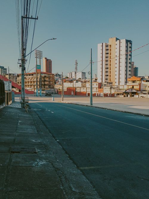 Free Quiet urban street view with modern buildings under clear blue sky. Stock Photo